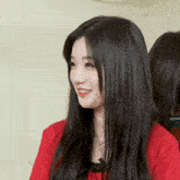 a woman with long black hair wearing a red shirt