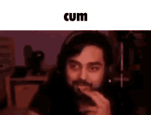 a man with a beard is wearing headphones and eating a piece of food .