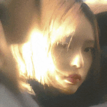 a close up of a woman 's face with a light shining on her face