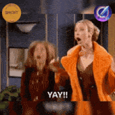 two women are standing next to each other and one says yay