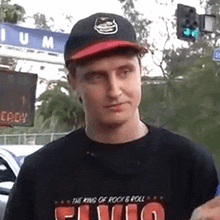 a man wearing a elvis shirt and a baseball cap