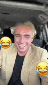 a man in a suit is laughing with tears coming out of his eyes while sitting in a car