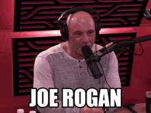 a man wearing headphones is talking into a microphone and the name joe rogan is on the screen