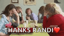 a group of people are sitting at a table and laughing .