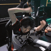 a man wearing headphones sitting in front of a keyboard