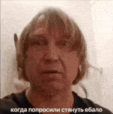 a man with blonde hair is taking a selfie in a bathroom with a caption in russian .
