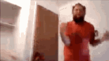 a man with a beard is dancing in a room .