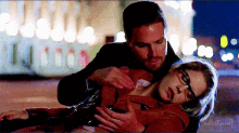 a man is holding a woman who is laying on the ground with a blurred background and the words callistawalk visible