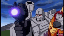 two transformers are standing next to each other and one of them is pointing a gun at the camera .