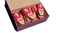a box of donuts with a pink and white face on them