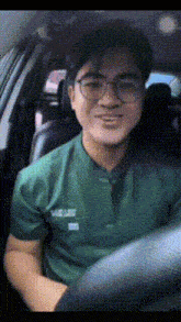 a man wearing glasses is driving a car and smiling for the camera