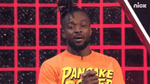 a man is wearing an orange shirt that says pancake