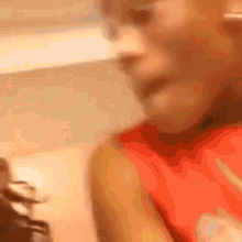 a close up of a person 's face in a red shirt .