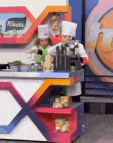 two female chefs are preparing food in front of a knorr sign .