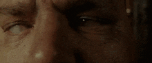 a close up of a man 's face with a tear coming out of his eye .