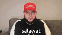 a man with a beard wearing a red hat that says " the muslim metaphysician "