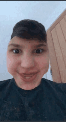 a young man is making a funny face with his mouth open and his eyes closed .