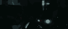 a person is standing in a dark room with a light coming out of the window .