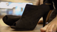 a close up of a woman 's foot wearing a pair of black shoes that say be emotion