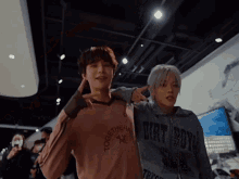 two young men are posing for a picture and one of them is wearing a dirty boy sweatshirt
