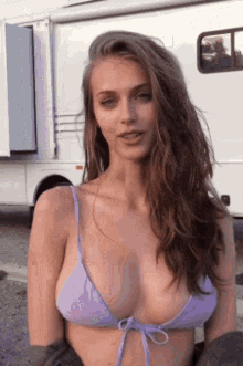 a woman in a bikini is standing in front of a white van .