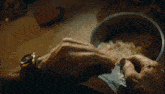 a close up of a person 's hand holding a bowl of food .