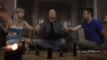 a man and a woman sit on the floor holding hands