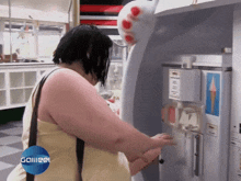 a woman is standing in front of a machine that says galiee on it