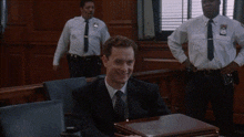 a man in a suit and tie is smiling in a court room