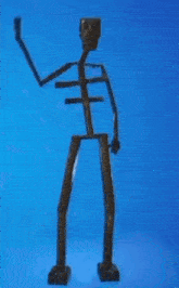 a skeleton made out of wood is standing on a blue surface .