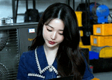 a woman wearing a denim shirt is looking down at something