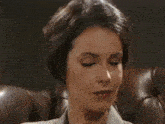 a woman is sitting on a leather couch and looking at the camera