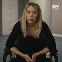 a woman sits in a chair with her hands folded in front of a hbo max logo