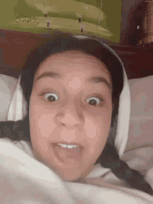 a girl with pigtails is making a funny face while laying in bed