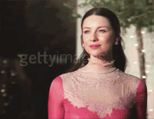 a woman in a pink dress is standing in front of a sign that says getty images