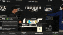 two men standing in front of a sign that says ufc 314