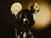 a close up of a mickey mouse statue with a clock on it 's face .