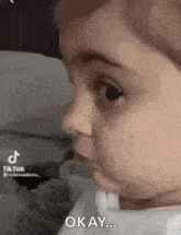 a baby is making a funny face and saying `` okay ... '' .