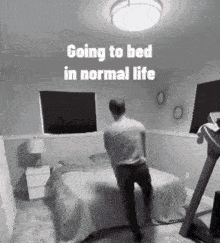 a man is standing on a bed in a bedroom with a treadmill .