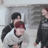 a group of young men are standing around a table and one of them is wearing a subaru sweatshirt