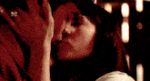 a man and a woman are kissing and the woman is wearing a ring