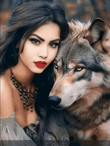 a woman with red lipstick stands next to a large gray wolf