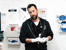 a man wearing gloves stands in front of a sign that says " your pain "