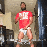 a man in a red shirt is dancing in a kitchen while taking off his underwear .