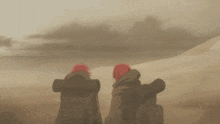 a couple of people standing in a desert with backpacks