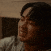 a close up of a man crying with his eyes closed .
