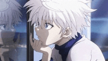 a young boy with white hair is looking out of a window .