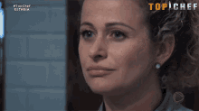 a close up of a woman 's face in front of a screen that says top chef estreia