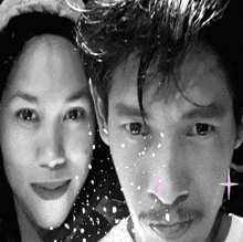 a man and a woman are posing for a picture with snow falling on them