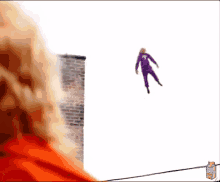 a person in a purple suit is flying through the air next to a box of lysol